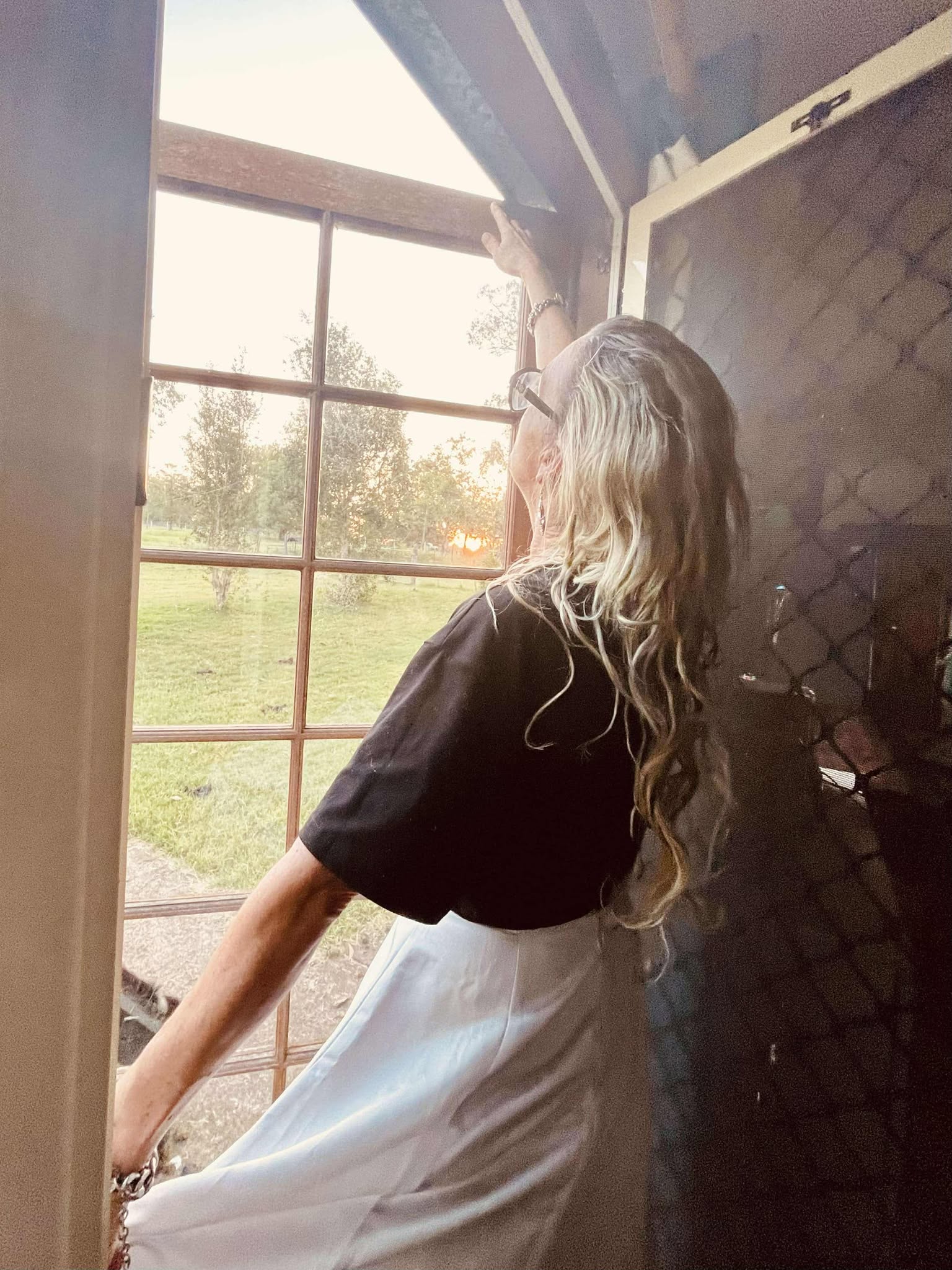Lady looking out glass door looking into paddock at content creator venue in churchable, lockyer valley