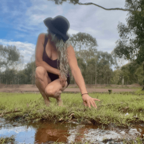 lady kneeling next to dam in lockyer valley farm venue for content creators