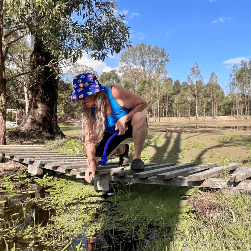 lady leaning down over dam